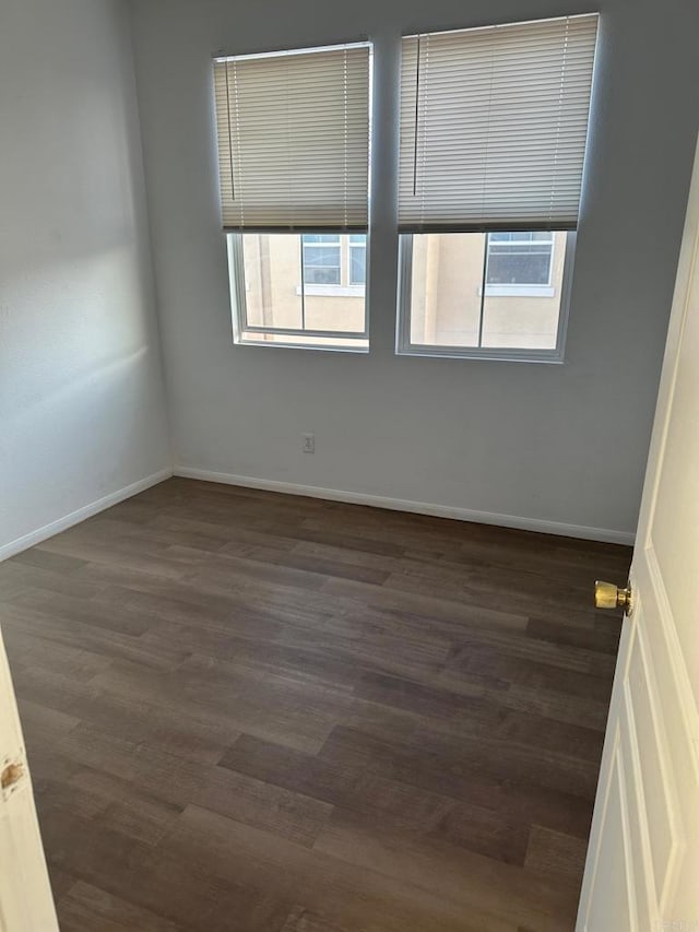 empty room with dark hardwood / wood-style flooring