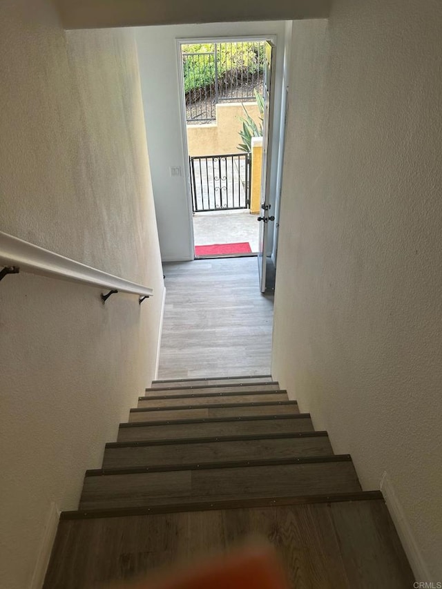 staircase with hardwood / wood-style flooring