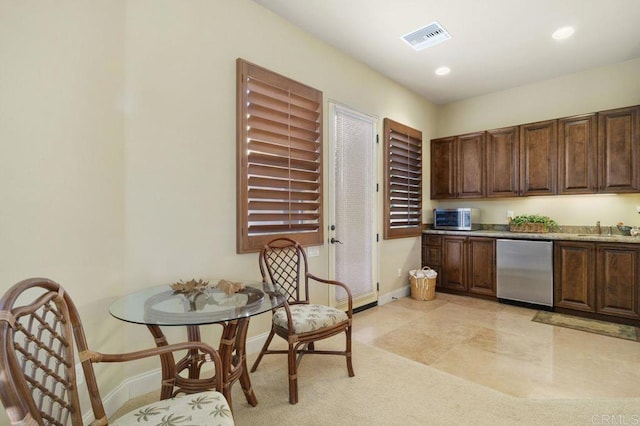 kitchen with dishwasher, a sink, visible vents, and baseboards