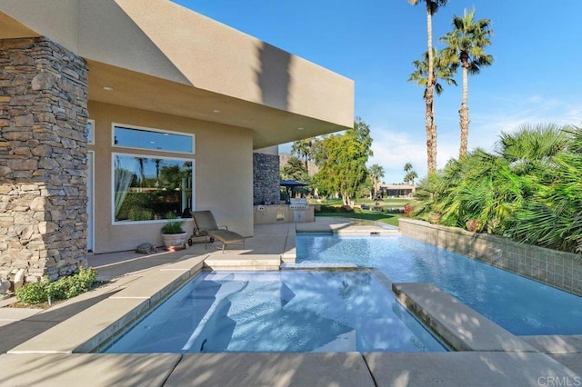 view of swimming pool featuring a pool with connected hot tub and a patio