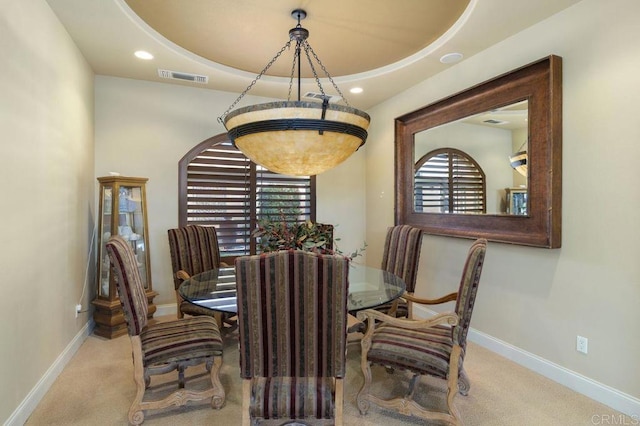 carpeted dining room with a tray ceiling, visible vents, baseboards, and recessed lighting