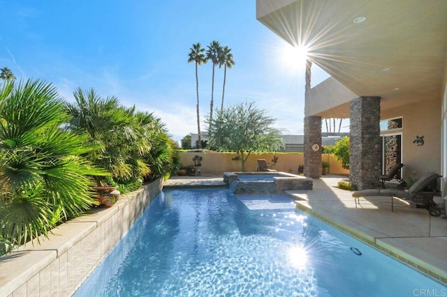 view of pool featuring a patio area, a fenced backyard, and a pool with connected hot tub