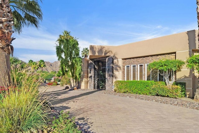 view of front of house featuring stone siding and stucco siding