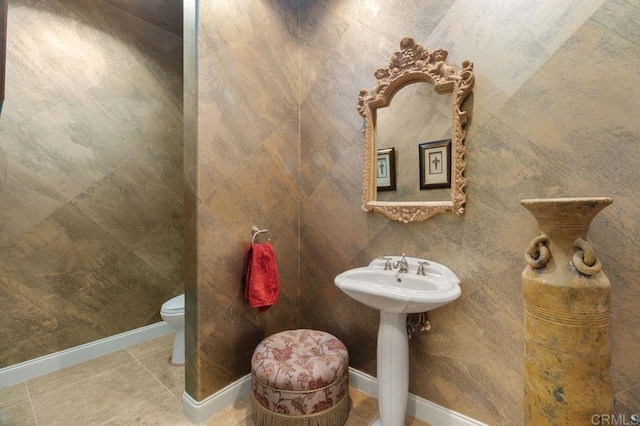 bathroom featuring baseboards, toilet, and tile patterned floors