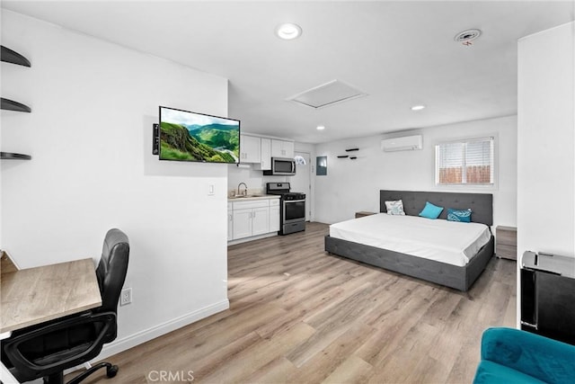 bedroom with sink, light hardwood / wood-style floors, and a wall mounted air conditioner