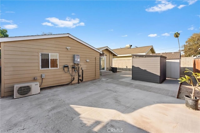 back of house featuring a patio area, a storage shed, and ac unit