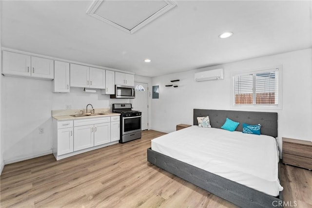 bedroom with a wall mounted AC, light hardwood / wood-style floors, and sink