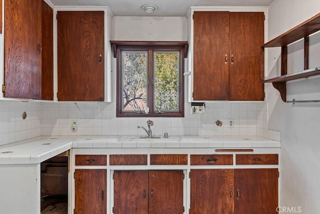 kitchen featuring decorative backsplash, sink, and tile counters