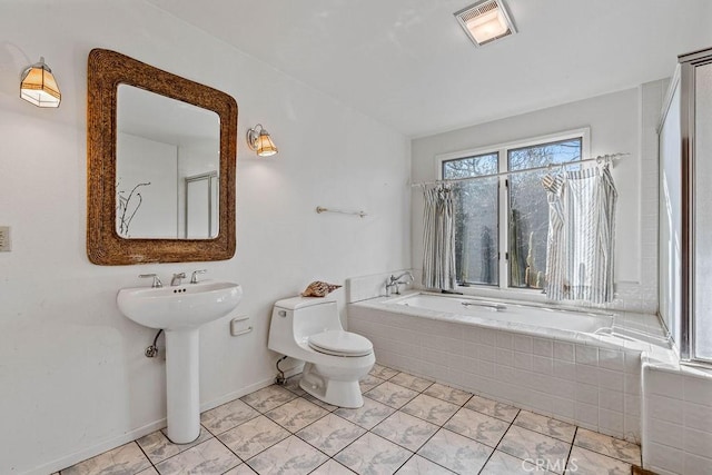 bathroom with toilet, tile patterned flooring, a relaxing tiled tub, and sink