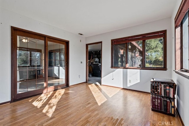 spare room with ceiling fan and light wood-type flooring