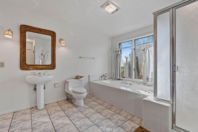 bathroom with toilet, tile patterned floors, and tiled tub