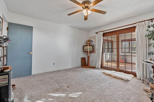 carpeted spare room featuring ceiling fan, french doors, and a textured ceiling