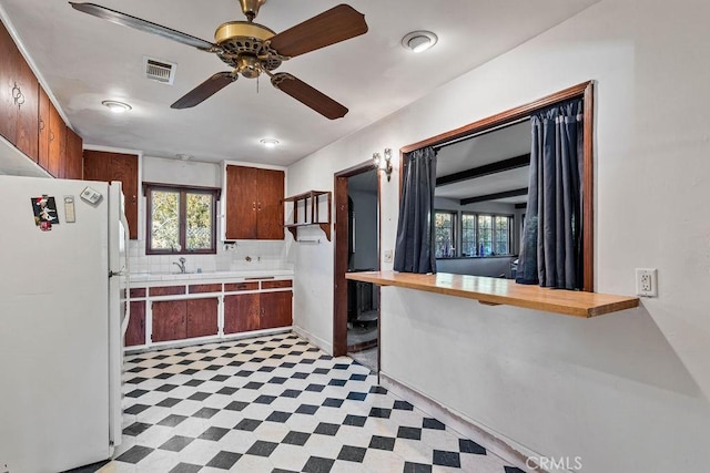 kitchen with wooden counters, white refrigerator, sink, backsplash, and ceiling fan