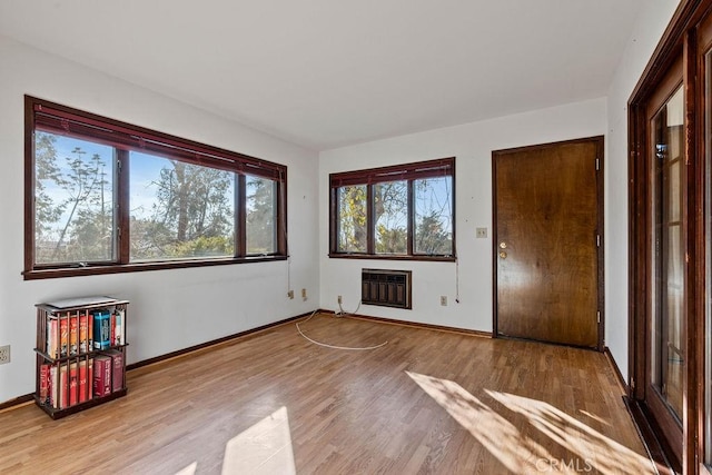 unfurnished bedroom featuring light wood-type flooring and heating unit