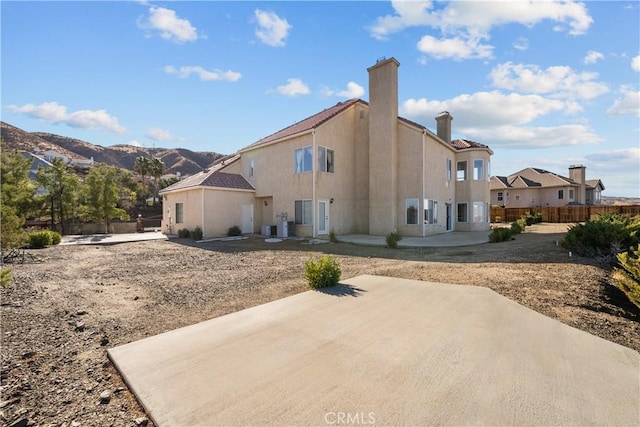 back of property featuring a mountain view and a patio