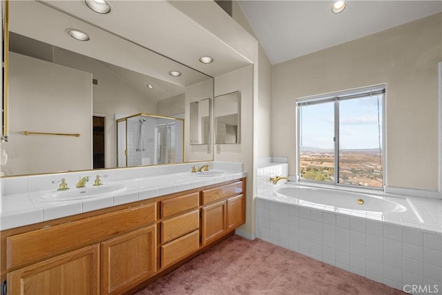 bathroom with shower with separate bathtub, vanity, and vaulted ceiling