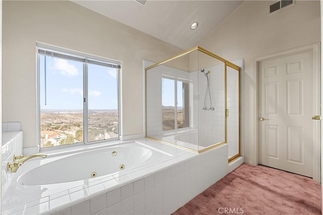 bathroom with plenty of natural light, independent shower and bath, and vaulted ceiling