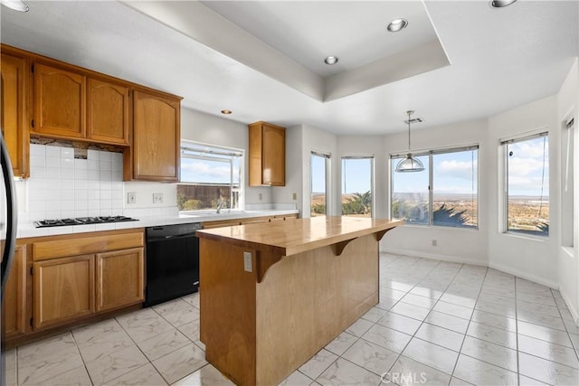 kitchen featuring decorative light fixtures, dishwasher, a kitchen island, gas stovetop, and wood counters