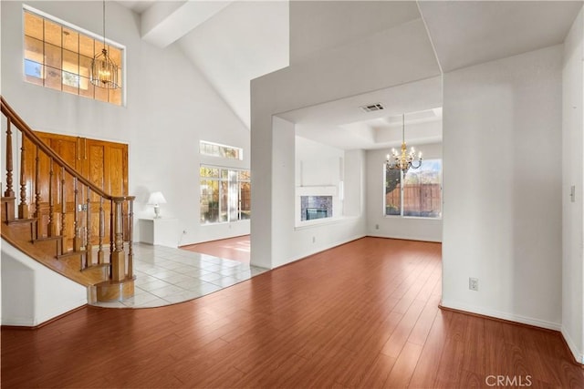 foyer entrance featuring hardwood / wood-style flooring, a wealth of natural light, and an inviting chandelier