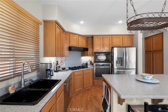 kitchen featuring light wood-style flooring, under cabinet range hood, black appliances, a sink, and recessed lighting