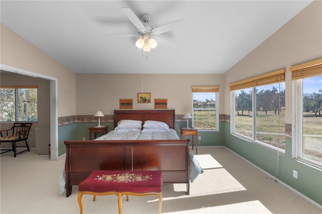 bedroom with lofted ceiling, light carpet, a ceiling fan, and baseboards