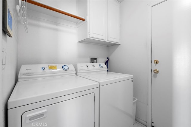 washroom featuring washing machine and dryer and cabinet space