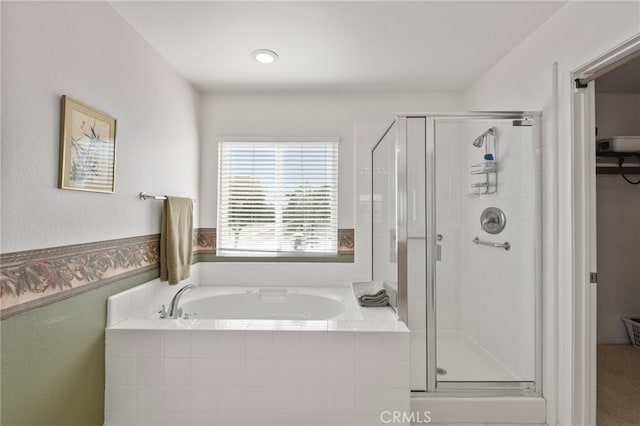 full bathroom featuring a garden tub and a shower stall