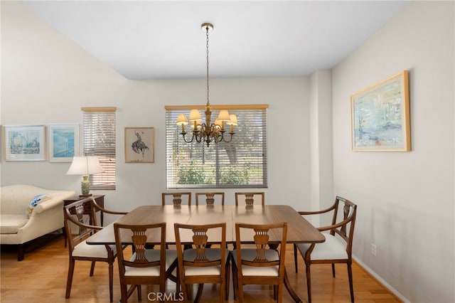 dining room with baseboards, light wood-type flooring, and an inviting chandelier