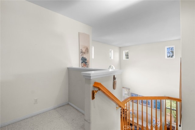 hallway with baseboards and an upstairs landing