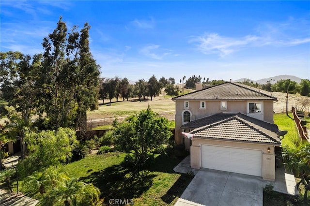 view of front of house featuring a garage, a mountain view, and a front lawn