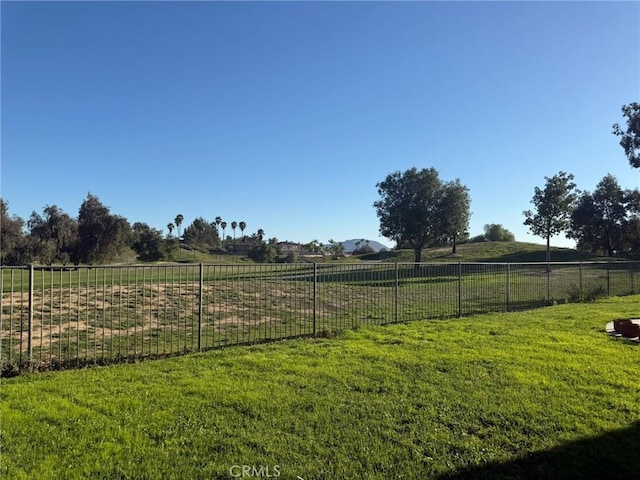 view of yard with fence and a rural view