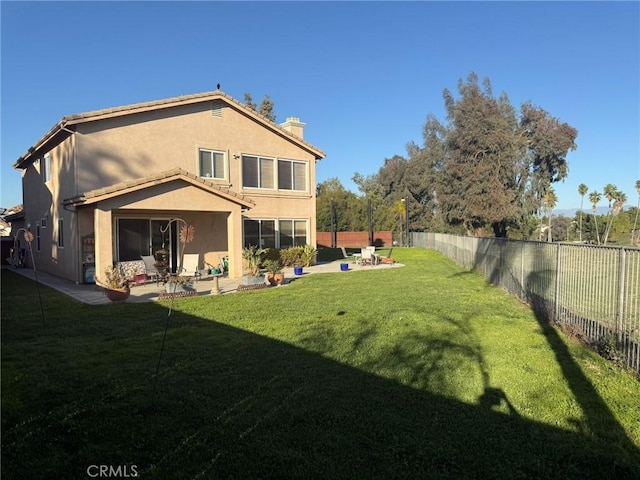 back of house featuring a patio, a lawn, a fenced backyard, and stucco siding