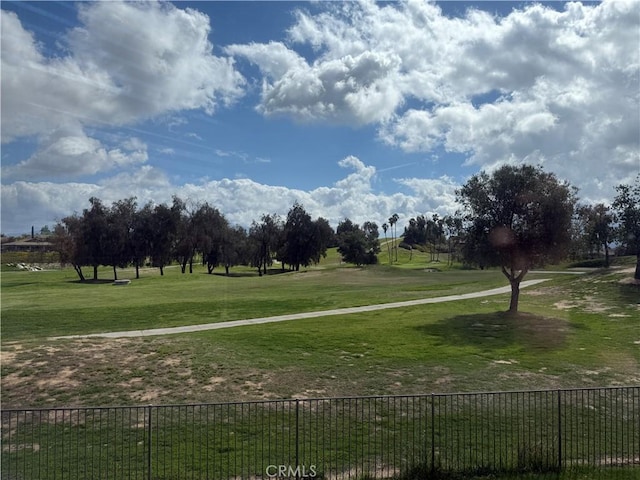 view of property's community with fence and a lawn