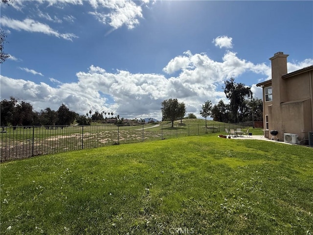 view of yard with a rural view, fence, and a patio