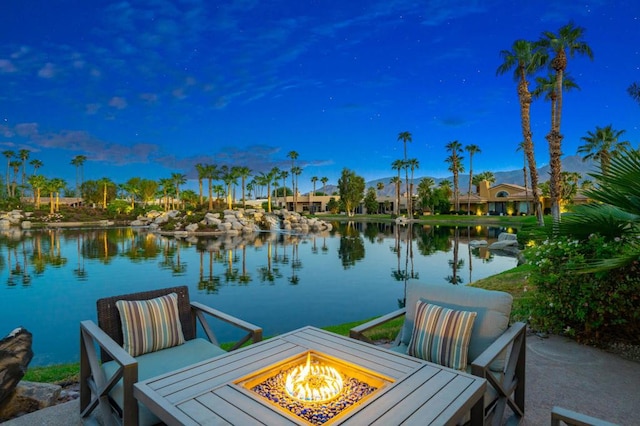 view of dock with a water view and a fire pit