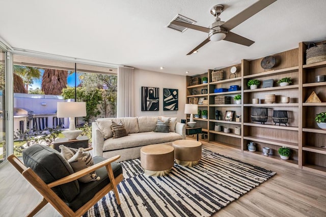 interior space featuring ceiling fan, expansive windows, and wood-type flooring