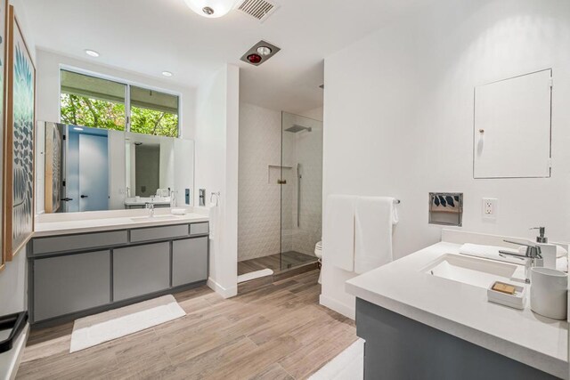 bathroom featuring vanity, hardwood / wood-style flooring, and tiled shower