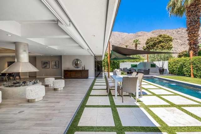 view of patio / terrace featuring a fenced in pool, pool water feature, and a mountain view