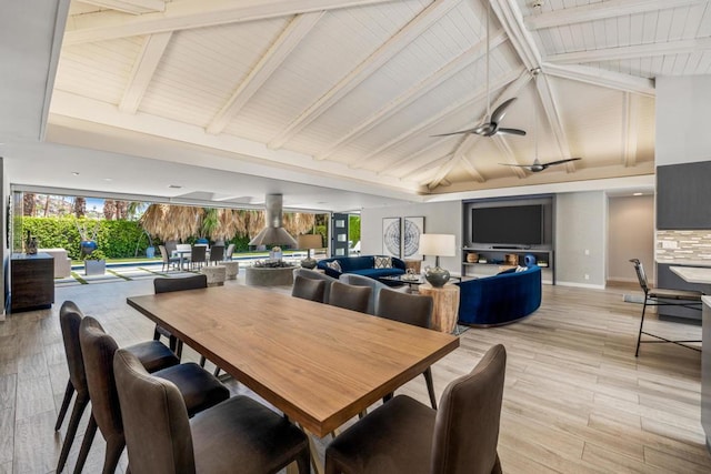 dining area with ceiling fan, light hardwood / wood-style flooring, and lofted ceiling with beams