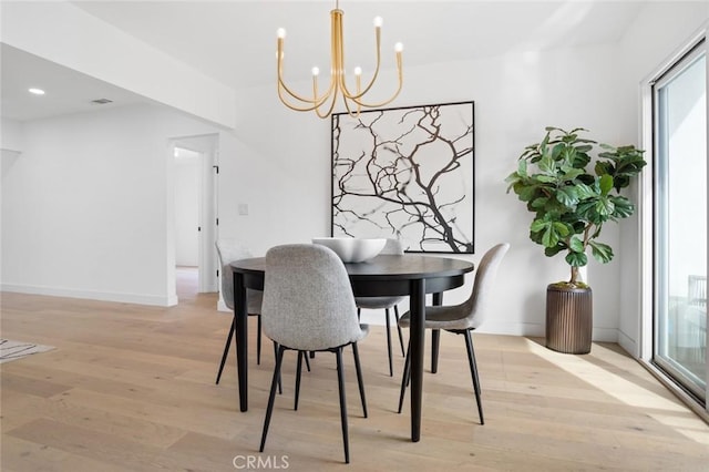 dining room featuring light hardwood / wood-style floors and a notable chandelier