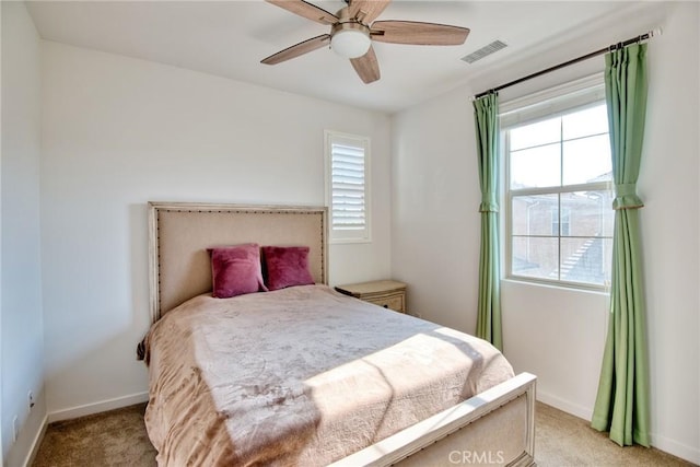 bedroom with baseboards, a ceiling fan, visible vents, and light colored carpet