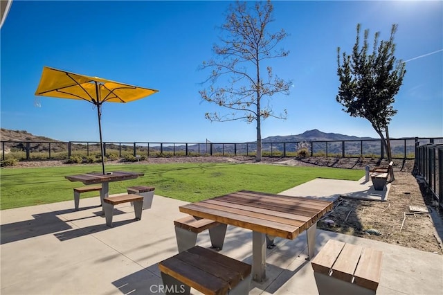 surrounding community featuring a patio area, a mountain view, a lawn, and fence