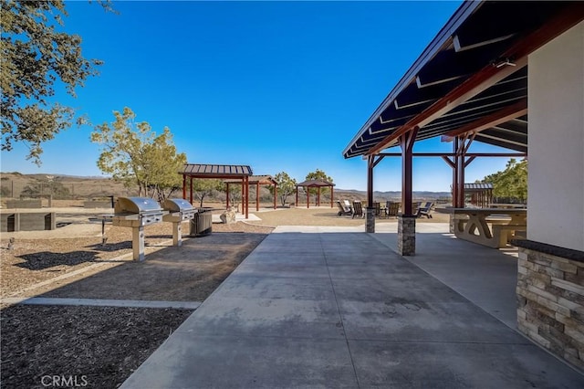 view of patio with a pergola, exterior kitchen, and a gazebo