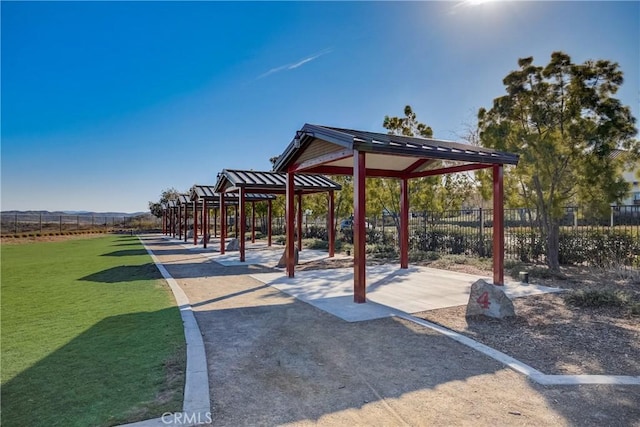 view of property's community with playground community, fence, and a lawn