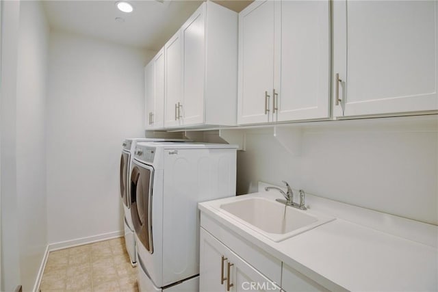 laundry room with recessed lighting, a sink, baseboards, cabinet space, and washer and clothes dryer