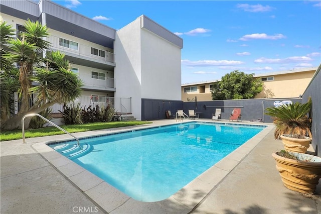 community pool featuring a patio and fence