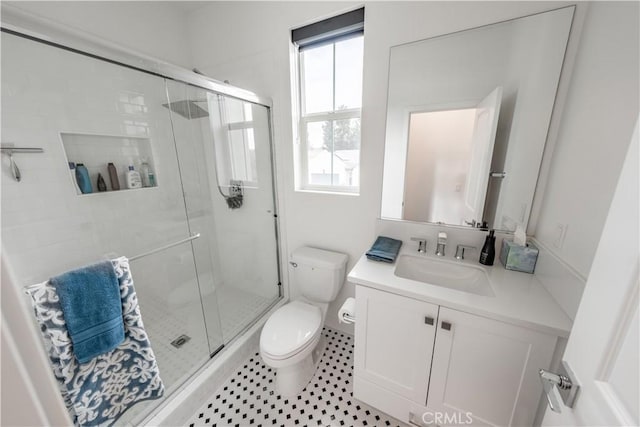 bathroom with toilet, a shower with shower door, and vanity