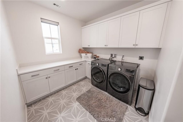 laundry room with cabinets and washing machine and clothes dryer