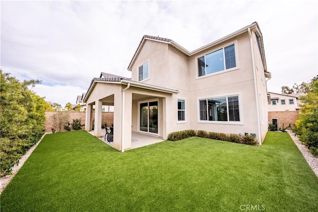 back of house featuring a lawn and a patio