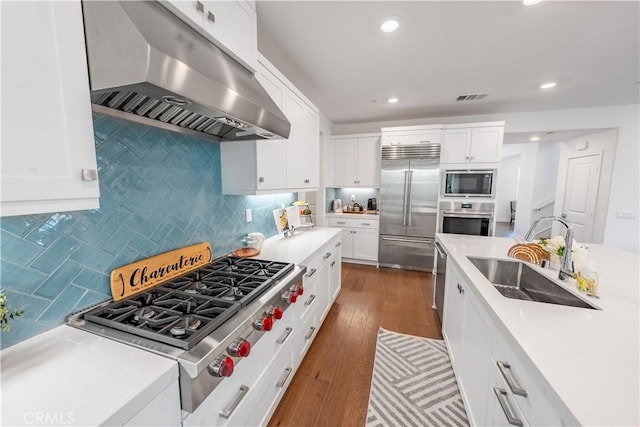 kitchen with white cabinetry, sink, and built in appliances